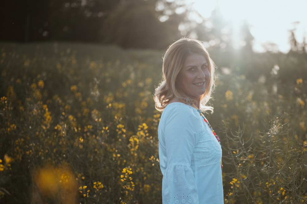 Business Shooting – Frau im weißen Kleid lächelt im Blumenfeld, MALEA Fotografie Darmstadt
