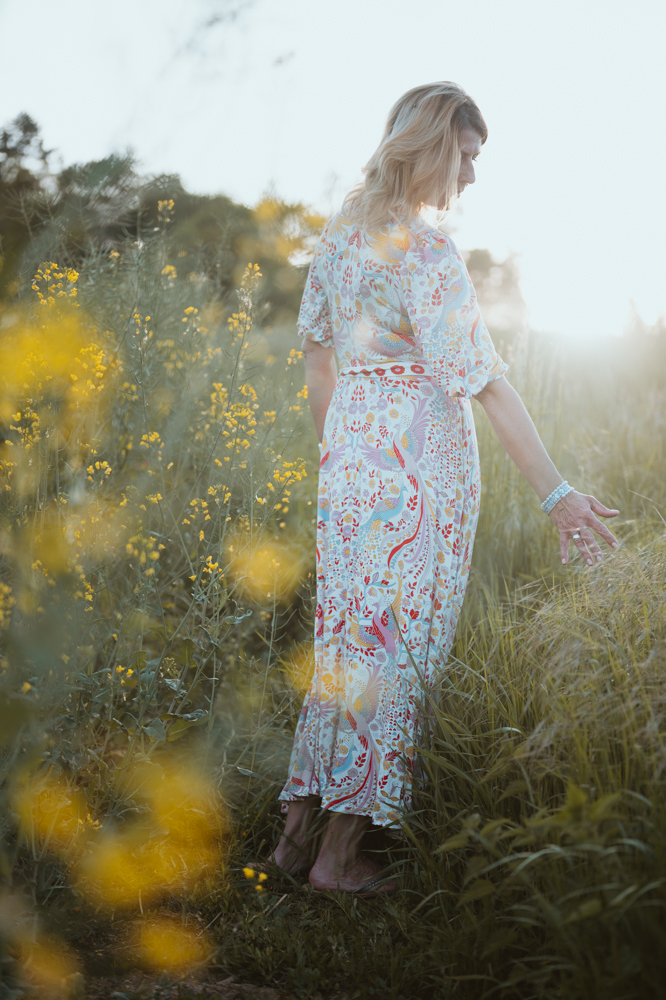 Frau von hinten in sommerlichem Blumenfeld im Gegenlicht – Frauenfotografie Darmstadt