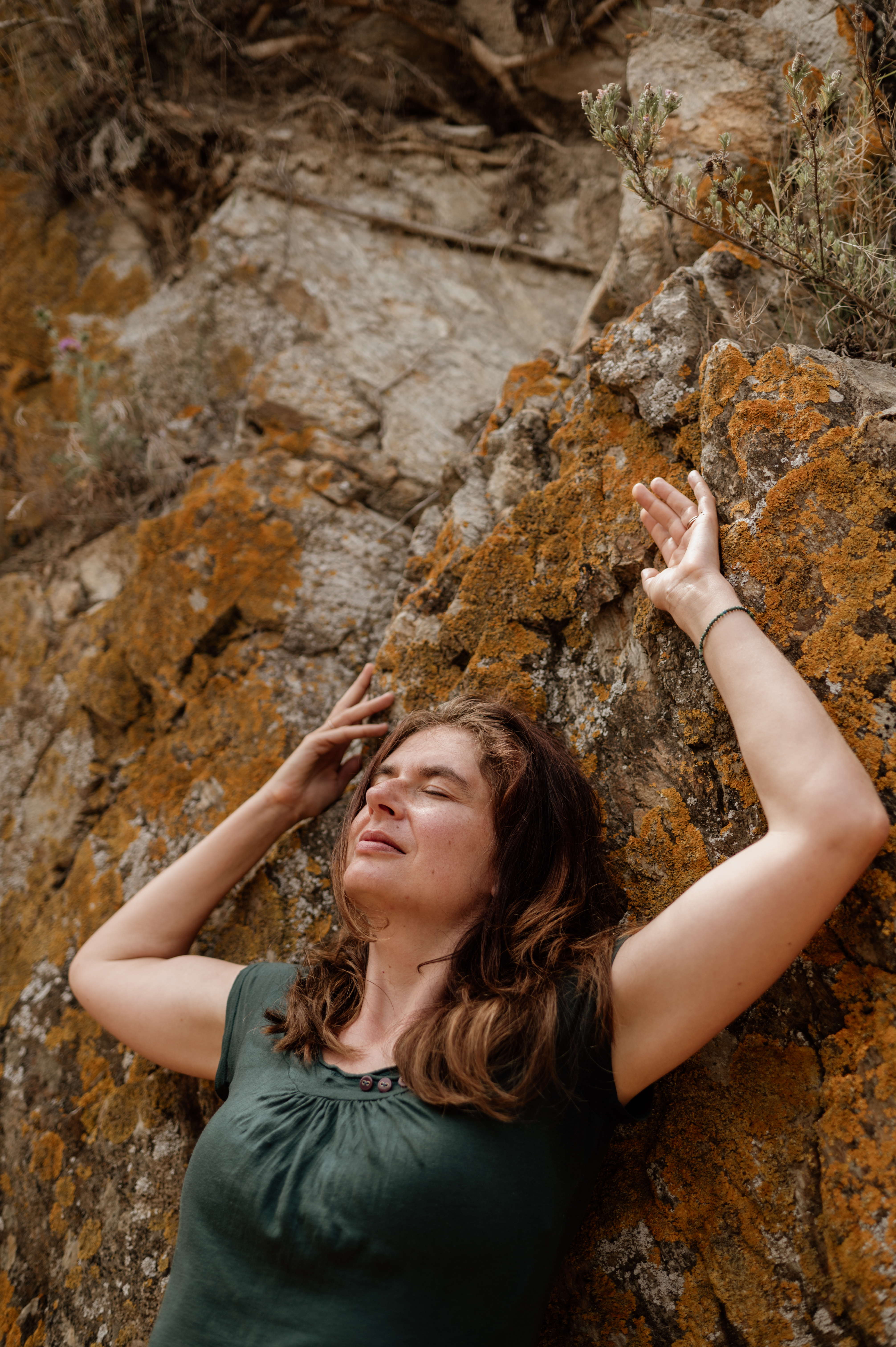 Mareen mit erhobenen Armen an einer Felswand – Erdung beim Retreat in Spanien, MALEA Fotografie